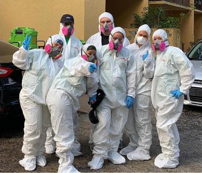 Seven employees dressed in PPE clothing to work on mold damage